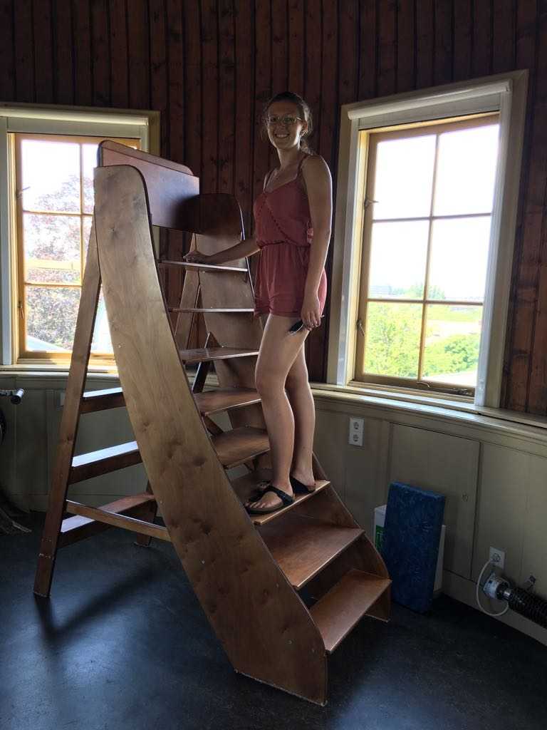 Photo: a photo of me in the main telescope dome of the observatory, standing on the stairs used for observing through the telescope.