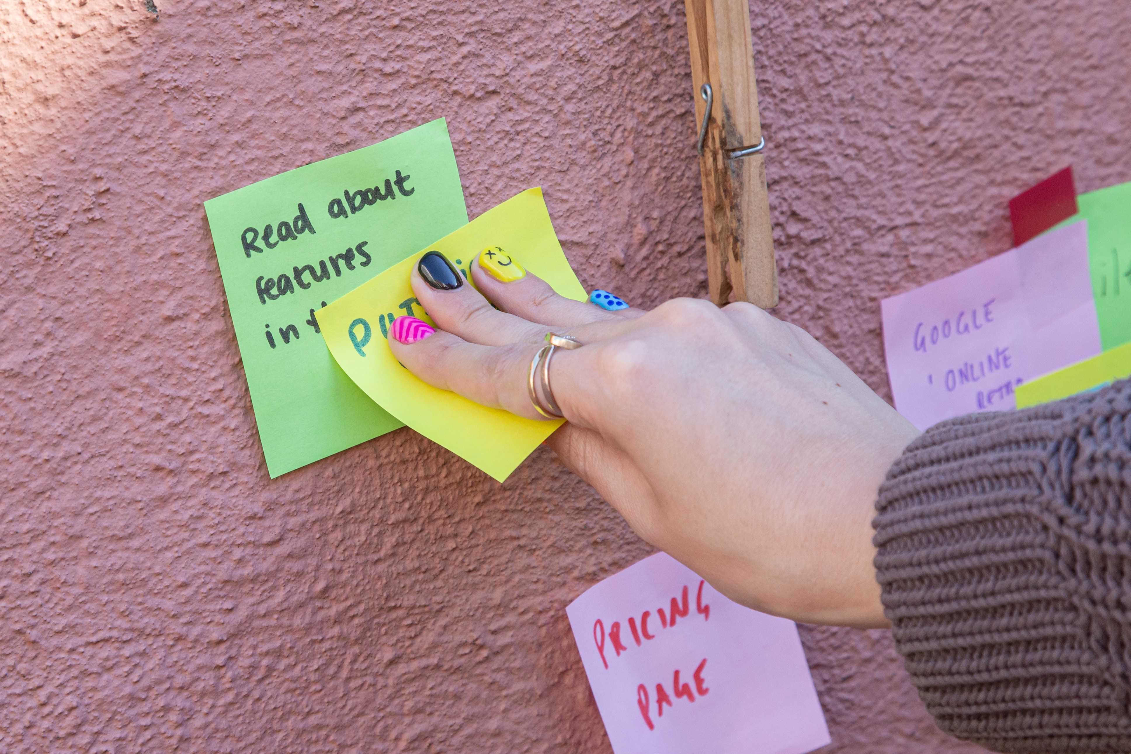 Image of a woman sticking post-it notes on a wall